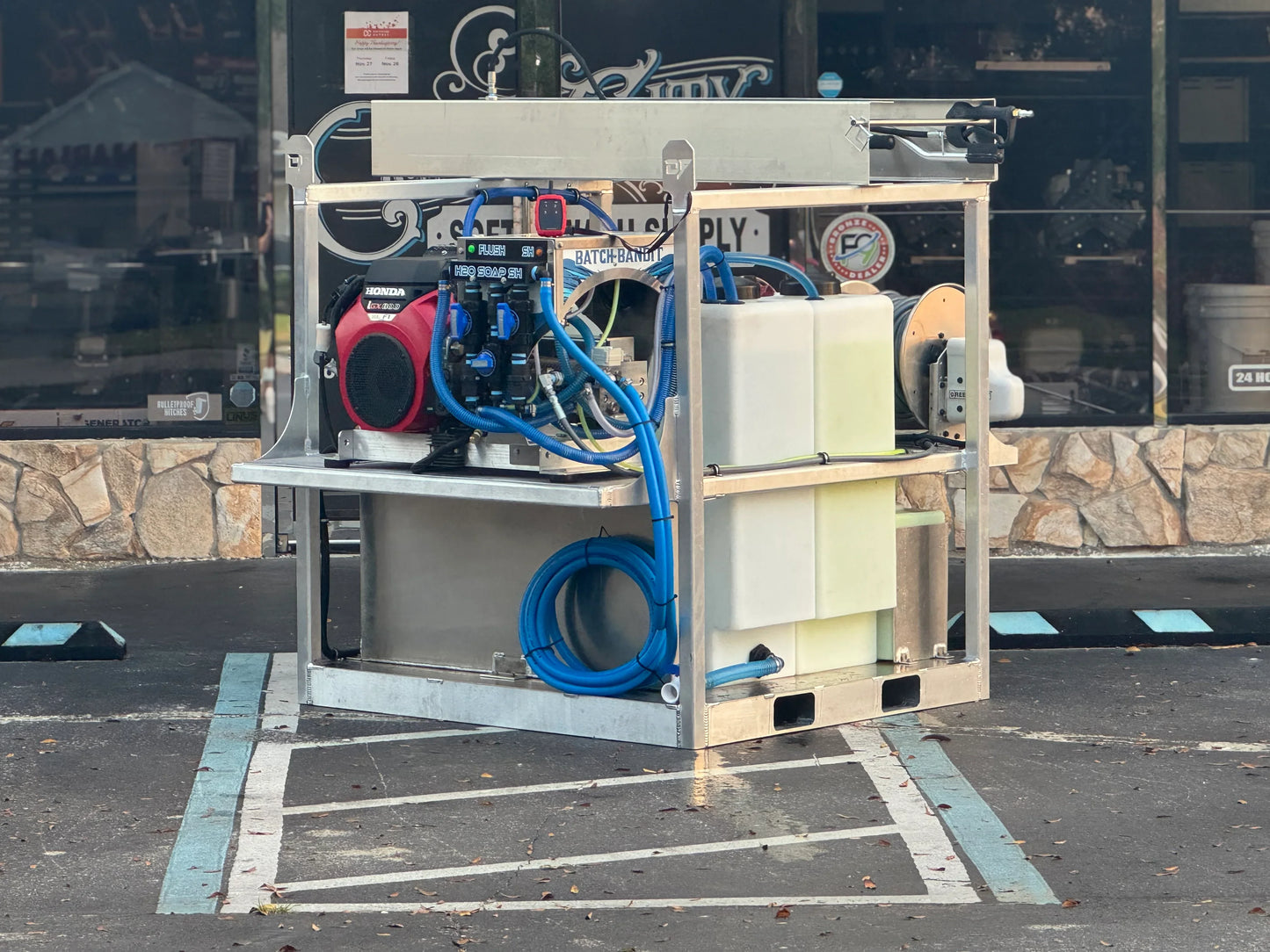 Portable softwash system with Honda engine, blue hoses, and chemical tanks for exterior cleaning solutions
