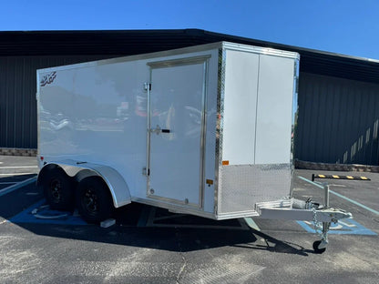 White enclosed utility trailer with ramp door, dual axles, and diamond plate accents for softwash equipment transport