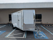 White enclosed utility trailer parked in accessible lot, ideal for softwash equipment transport