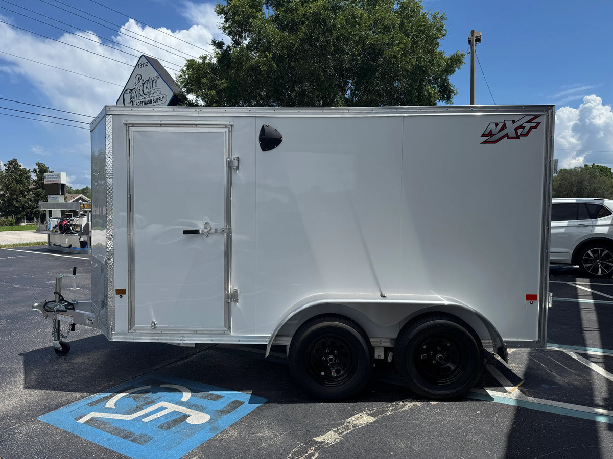 White NXT softwash trailer parked in lot, ideal for professional cleaning equipment transport.