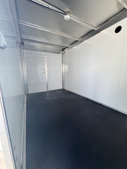 Spacious interior of a softwash equipment trailer with white walls and black flooring