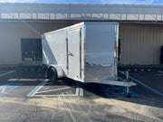White enclosed utility trailer with diamond plate accents, parked outdoors for softwash equipment transport