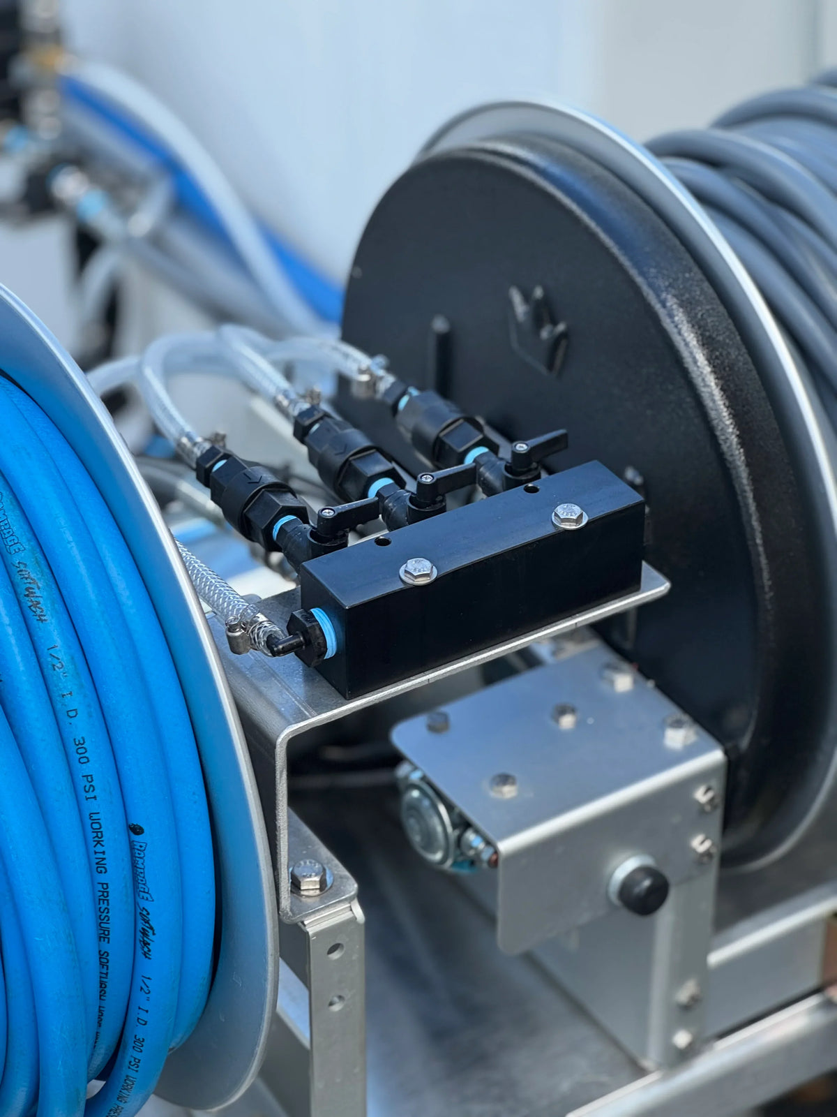 Softwash equipment with blue hoses and pressure valves for professional cleaning systems