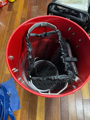Red softwash bucket with black mesh filter and metal handle for cleaning equipment