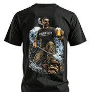 Black softwash t-shirt with graphic of man holding beer, smoking cigar, using pressure washer on monkey