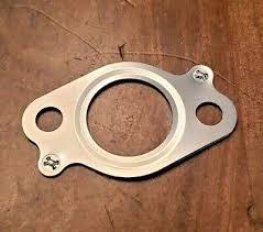 Metal softwash equipment gasket with bolt holes on wooden surface
